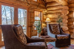 a room with two chairs and a table in a log cabin at Buffalo Creek Lodge in West Jefferson