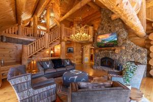 a living room with a stone fireplace in a log cabin at Buffalo Creek Lodge in West Jefferson