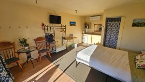 a bedroom with a bed and a table and chairs at Bahara Accommodation in Springfield