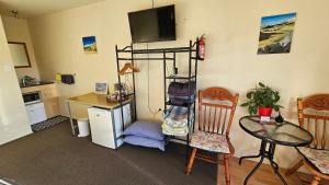 a room with a desk and a kitchen with a table at Bahara Accommodation in Springfield