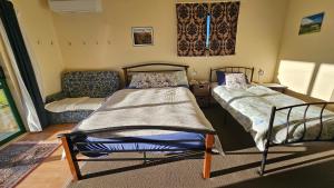 a bedroom with two beds and a couch at Bahara Accommodation in Springfield