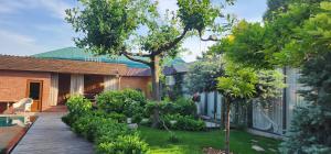a garden with a wooden walkway next to a house at Garda in Tashkent