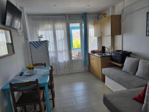 a small living room with a table and a kitchen at Tony's Rooms in Alinda