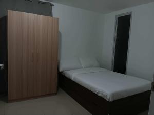 a bedroom with a bed and a wooden cabinet at California style Resident in Iloilo City +8 photos