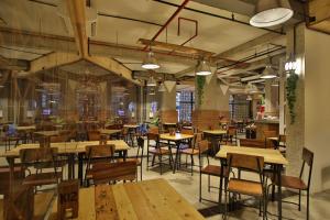 an empty restaurant with wooden tables and chairs at J Hotel Kuta in Kuta
