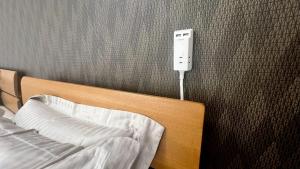 a bedroom with a bed and a stimulator on a wall at Guesthouse Yu in Yomitan