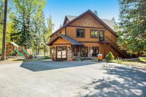 a wooden house with a driveway in front of it at Wooded Dreams in Whitefish