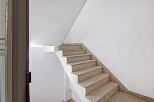 a staircase in a house with a white wall at Hotel O Ethereal Inn in New Delhi