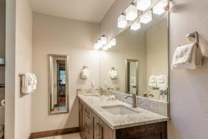 a bathroom with a sink and a large mirror at Tamarack Terrace in Lakeside +65 photos