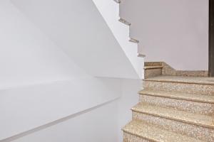 a stairway with a white wall and a stair case at Hotel O Ethereal Inn in New Delhi