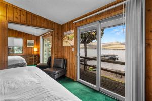a bedroom with a bed and a large window at The Meadowlark Cabin in Big Arm