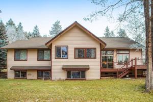 a large house with a porch and a deck at Paniolo Inn in Whitefish