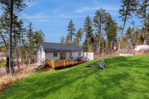 a small house in the middle of a green field at Happy Valley Hideaway in Whitefish