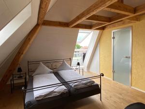 a bedroom with a metal bed in a attic at Hopfengrün Langenthal in Langenthal