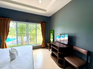 a bedroom with a bed and a desk and a window at KT Garden Villa in Ko Samui