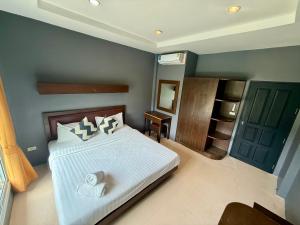 a bedroom with a white bed and a green door at KT Garden Villa in Ko Samui