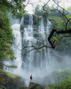 a person standing in front of a waterfall at Beyond ella in Ella +7 photos