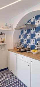 a kitchen with blue and white tiles on the wall at VillaNina in Pontone