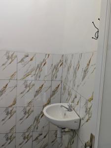 a white sink in a bathroom with marble tiles at Snooze hostel lombok in Selong Belanak +27 photos