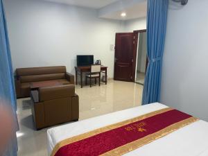 a bedroom with a bed and a couch and a chair at Hotel T88 in Ấp Trảng