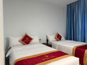 two beds in a room with blue curtains at Hotel T88 in Ấp Trảng +38 photos
