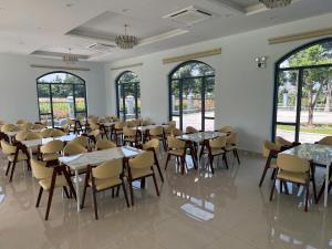 a dining room with tables and chairs and windows at Hotel T88 in Ấp Trảng