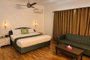 a hotel room with a bed and a couch at Sable d'Or Résidence by Star 'A' in Karachi