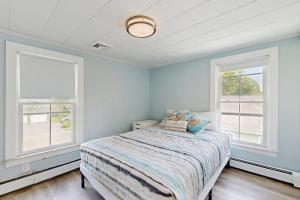 a bedroom with a bed and two windows at Salt Air Serenity in Old Orchard Beach