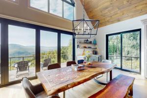 a dining room with a table and views of mountains at We'll Ski in Jackson