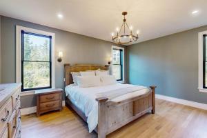 a bedroom with a large bed and two windows at We'll Ski in Jackson