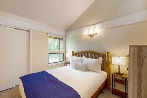 a bedroom with a large white bed with a blue blanket at Wister F in Teton Village
