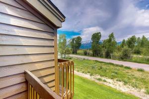 a house with a wooden porch with a view of a road at Wister F in Teton Village