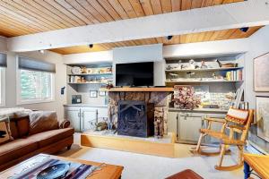 a living room with a fireplace and a couch at Ducks Unlimited 173 in Big Sky
