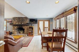 a living room with a table and a fireplace at Peaceful Home in North Conway