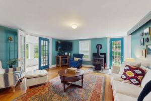 a living room with a white couch and a wood stove at The Wolfeboro House in Wolfeboro