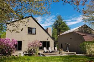 a house with two chairs and a patio in the yard at Peaceful Home in North Conway