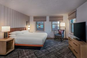 a hotel room with a bed and a television at Sheraton Commander Hotel in Cambridge