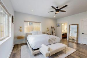 a white bedroom with a bed and a ceiling fan at Modern Mountain View Escape in Columbia Falls