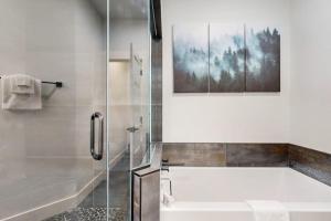 a bathroom with a shower and a tub and a sink at Modern Mountain View Escape in Columbia Falls +32 photos