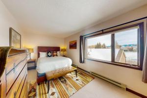 a bedroom with a bed and a large window at Teton Shadows Darwin F in Jackson