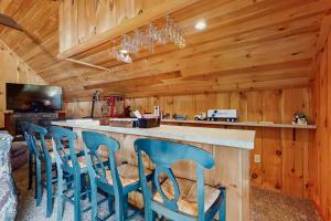 a kitchen with a large counter with blue bar stools at Owls' Hollow in West Dover