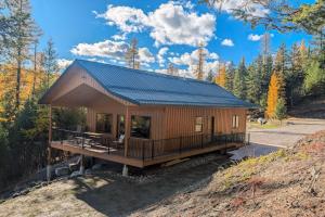 a cabin in the woods with a blue roof at Rocky Crest Retreat in Kalispell