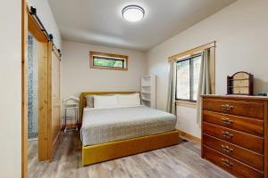 a bedroom with a bed and a dresser and a window at Rocky Crest Retreat in Kalispell