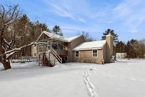 a house in the snow with a snow covered yard at White Mountain Trailhead in Campton