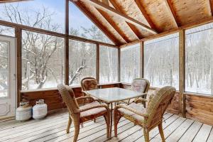 a screened in porch with a table and chairs at White Mountain Trailhead in Campton