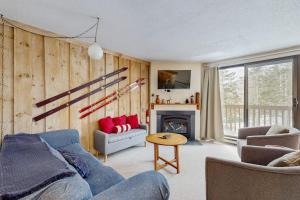 a living room with a blue couch and a fireplace at Mad House in Waterville Valley