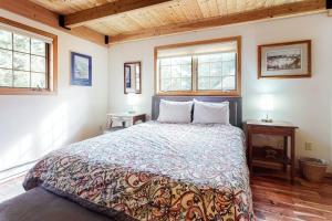 a bedroom with a bed with two tables and two windows at Lone Walker Home in Big Sky