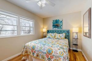 a bedroom with a bed and two windows at Champ's Camp in Colchester
