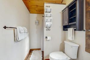 ein Badezimmer mit Toilette und Handtüchern an der Wand in der Unterkunft Moose Chalet in Bigfork