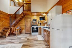 eine Küche mit einem weißen Kühlschrank und einer Treppe in der Unterkunft Moose Chalet in Bigfork
